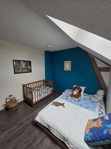 a childs bedroom with a bed with a blue wall at Le Bel Air en Berry in Reigny