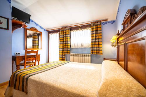 a bedroom with a bed and a table and a chair at Hotel del Pastor in Morella