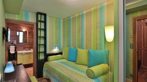 a living room with a couch in a room at Hôtel Le Cep & Spa in Beaune