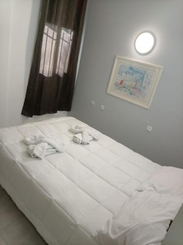a white bed in a room with a window at אלמוגי אוראל in Eilat