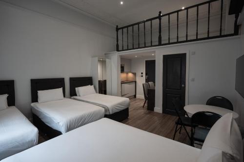 a hotel room with two beds and a table and chairs at MSK Elite in London