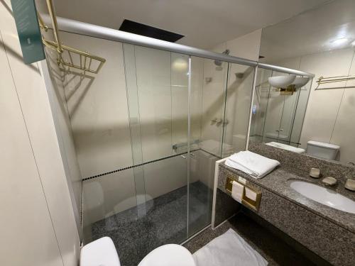 a bathroom with a glass shower and a sink at Kubitschek Plaza Hotel - Flat Particular ALM in Brasília