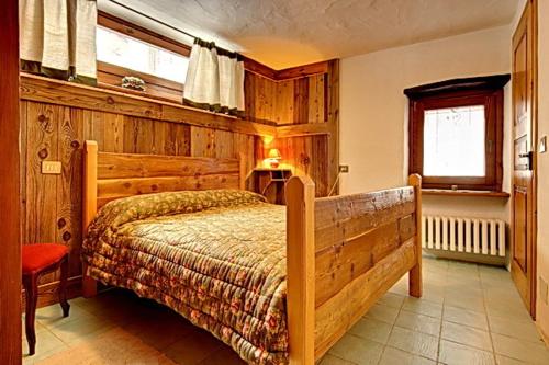 a bedroom with a wooden bed and a window at B&B A Pankeo in Valtournenche