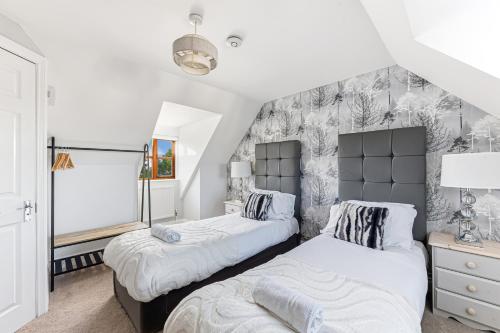 a bedroom with two beds and a wall mural at Loughton House - Central Location - Driveway Parking, Self-Check-In, Garden, Super-Fast Wifi and Smart TVs by Yoko Property in Milton Keynes