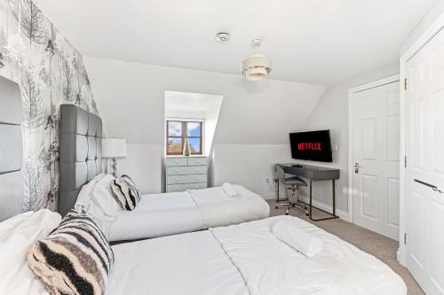 a white bedroom with two beds and a desk at Loughton House - Central Location - Driveway Parking, Self-Check-In, Garden, Super-Fast Wifi and Smart TVs by Yoko Property in Milton Keynes