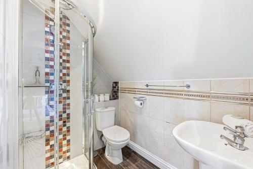 a bathroom with a toilet and a sink and a shower at Loughton House - Central Location - Driveway Parking, Self-Check-In, Garden, Super-Fast Wifi and Smart TVs by Yoko Property in Milton Keynes