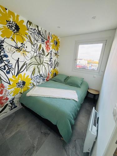 sypialnia z łóżkiem i ścianą w kwiaty w obiekcie sunset lodge calais w Calais
