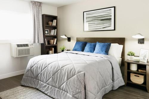 a bedroom with a large bed with blue pillows at InTown Suites Extended Stay Phoenix AZ - Chandler in Phoenix