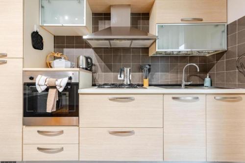 a kitchen with wooden cabinets and a stove top oven at Bilocale moderno a Conselve in Conselve