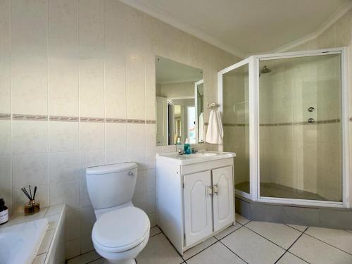 a bathroom with a toilet and a sink and a shower at Sunset View in Durbanville