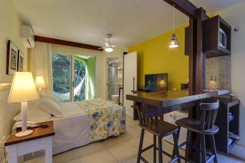 a bedroom with a bed and a kitchen with a counter at Pousada Vila do Bosque in Bombinhas