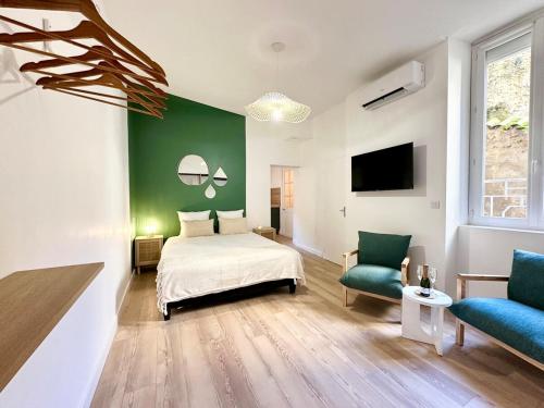 a bedroom with a bed and a green wall at Le SPA Étoilé - Baignoire Balnéo et Sauna Privatif in Mont-de-Marsan