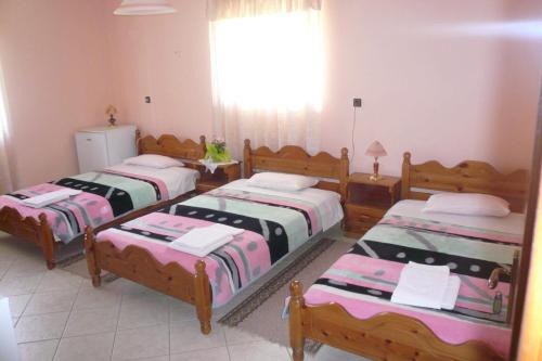 a bedroom with three beds and a window at Γαλήνη in Konitsa