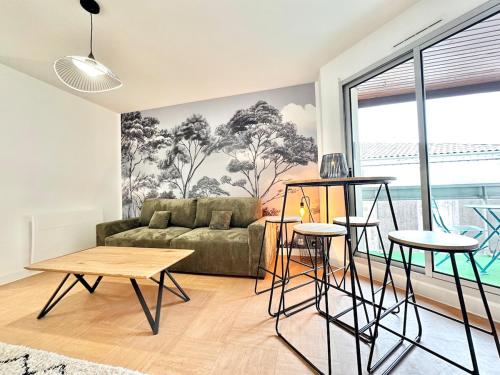 a living room with a couch and a table at Le Vert D'eau - Raffiné - Central - Balcon in Mont-de-Marsan
