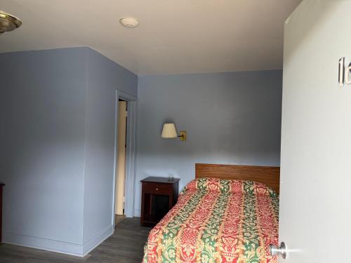 a bedroom with a bed with a colorful bedspread at Shady Grove Motel in Ashland