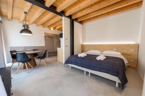 a bedroom with a bed and a table and chairs at Hillside House Sant'Andrea in Vittorio Veneto