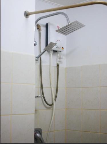 a shower with a hose in a bathroom at Secret Nest in Manila