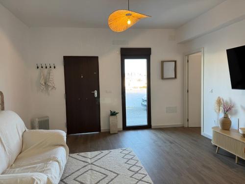 a living room with a white couch and a television at Las eras 84 in Níjar