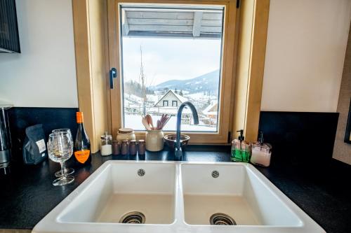 a large white sink in a kitchen with a window at Chata Jarabina in Terchová