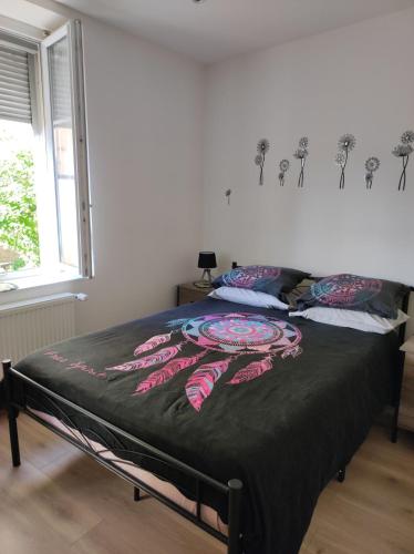 a bed with a black blanket on it in a bedroom at Appartement rez de chaussée - 2 chambres in Bischheim