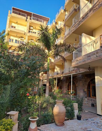 a building with two large vases in a courtyard at Thebes Hotel in Luxor