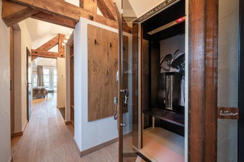 a hallway with a glass door and a room with a couch at Alpin Lifestyle Hotel Löwen & Strauss in Oberstdorf