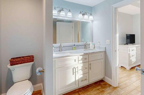 a bathroom with a toilet and a sink and a mirror at Tranquil Harbour 102 in Mexico Beach
