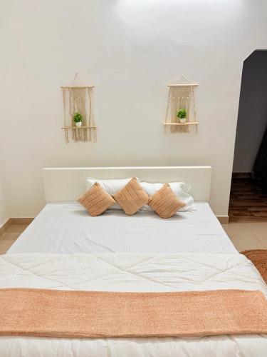 a bedroom with a white bed with two pillows at Serenyaa in Dibrugarh