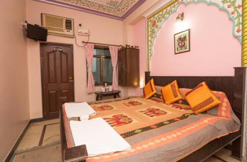 a bedroom with a bed with orange pillows at Hotel Moon Light Palace in Jaipur