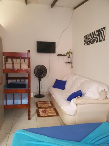 a living room with a white couch and a bunk bed at Kitnet Puro Dengo in São Francisco do Sul