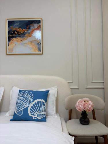 a bed with a blue pillow and a vase with a flower at Prime Stay Almaty & VIP Apartment in the center in Almaty