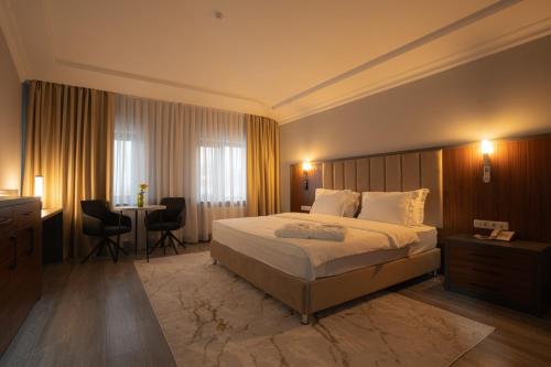 a hotel room with a bed and a table and chairs at Rauza Hotel Tashkent in Tashkent