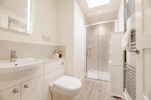 a white bathroom with a toilet and a shower at 3 Bed in Bamburgh oc-w31886 in Bamburgh