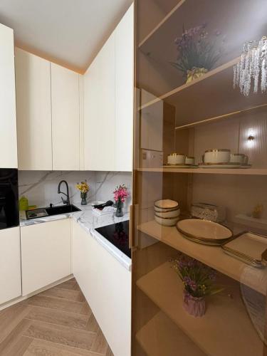 a kitchen with white cabinets and a sink at Prime Stay Almaty & VIP Apartment in the center in Almaty