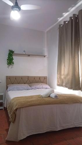 a bedroom with a large bed with a window at Quarto à 500m da praia Espaco Aconchego do Gugu in Arraial do Cabo