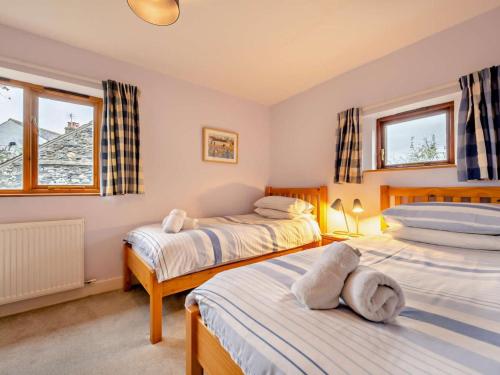 a bedroom with two beds and two windows at 3 Bed in Keswick oc-93590 in Threlkeld