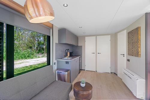 a living room with a couch and a large window at Houseboats Pean-buiten Weidum in Weidum