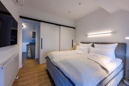 a bedroom with a large bed with white pillows at Quartier E in Naumburg
