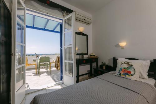 a bedroom with a bed and a door to a balcony at Victoria Studios & Apartments in Mikri Vigla