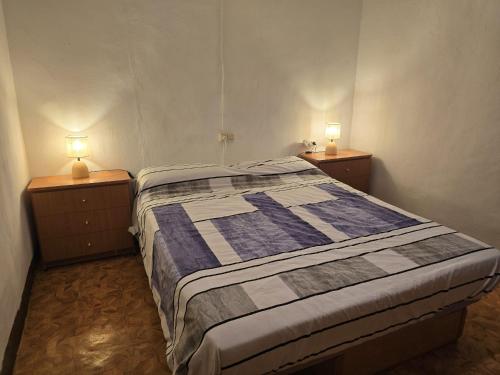 a bedroom with a bed and two night stands with lamps at Casa Castillo in Montán