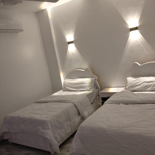 two beds in a room with lights on the wall at Diamond in Luxor