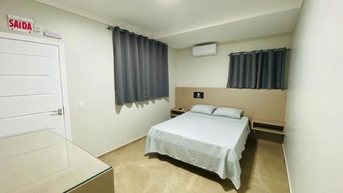 a bedroom with a bed in a room at Pousada Jabuticabeira in Jaguaruna