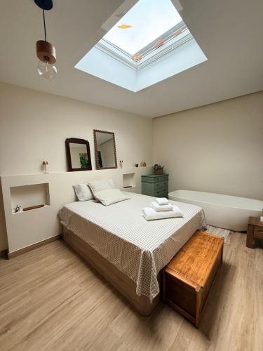 a bedroom with a large bed with a skylight at O Caliu das Airas in León