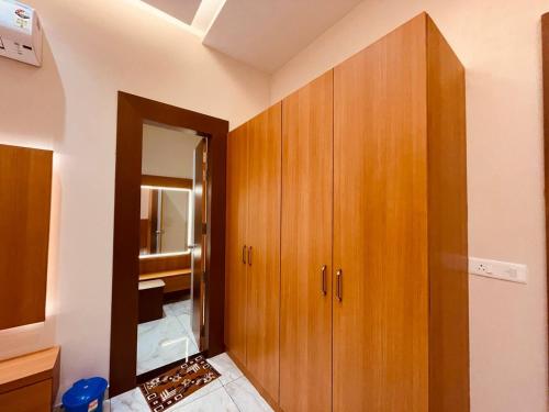 a bathroom with a wooden cabinet and a mirror at Shree Shivay Homestay in Sathri