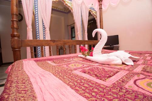 a bed with a swan decoration on it at Hotel Moon Light Palace in Jaipur