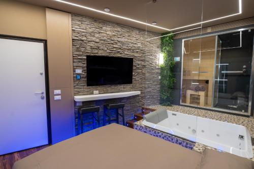 ein Badezimmer mit Badewanne und Fernseher in der Unterkunft Suite Roma15 in Roccaraso
