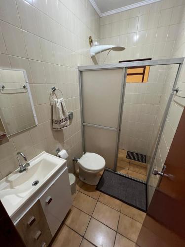 a bathroom with a shower and a toilet and a sink at Casa da lagoa in Imbituba