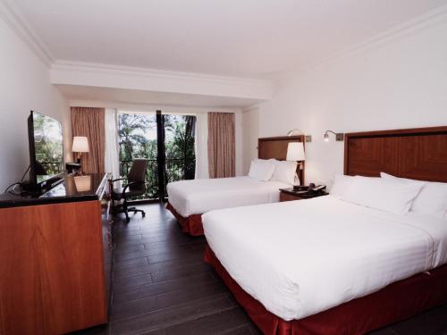 a hotel room with two beds and a television at HS HOTSSON Hotel Tampico in Tampico