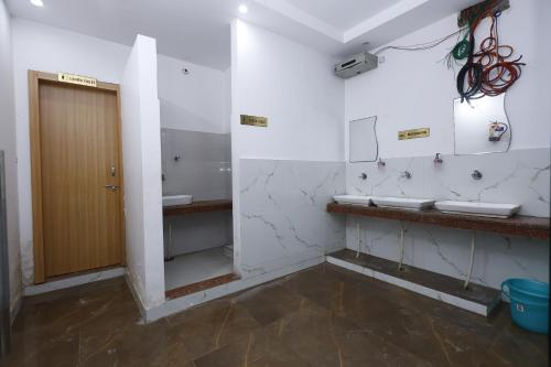 a bathroom with two sinks and a wooden door at New Awadhesh Singh Hotel in Chauri