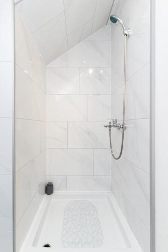 a white bathroom with a tub and a shower at Chic Palace - Boutique studio apartment in Vukovar